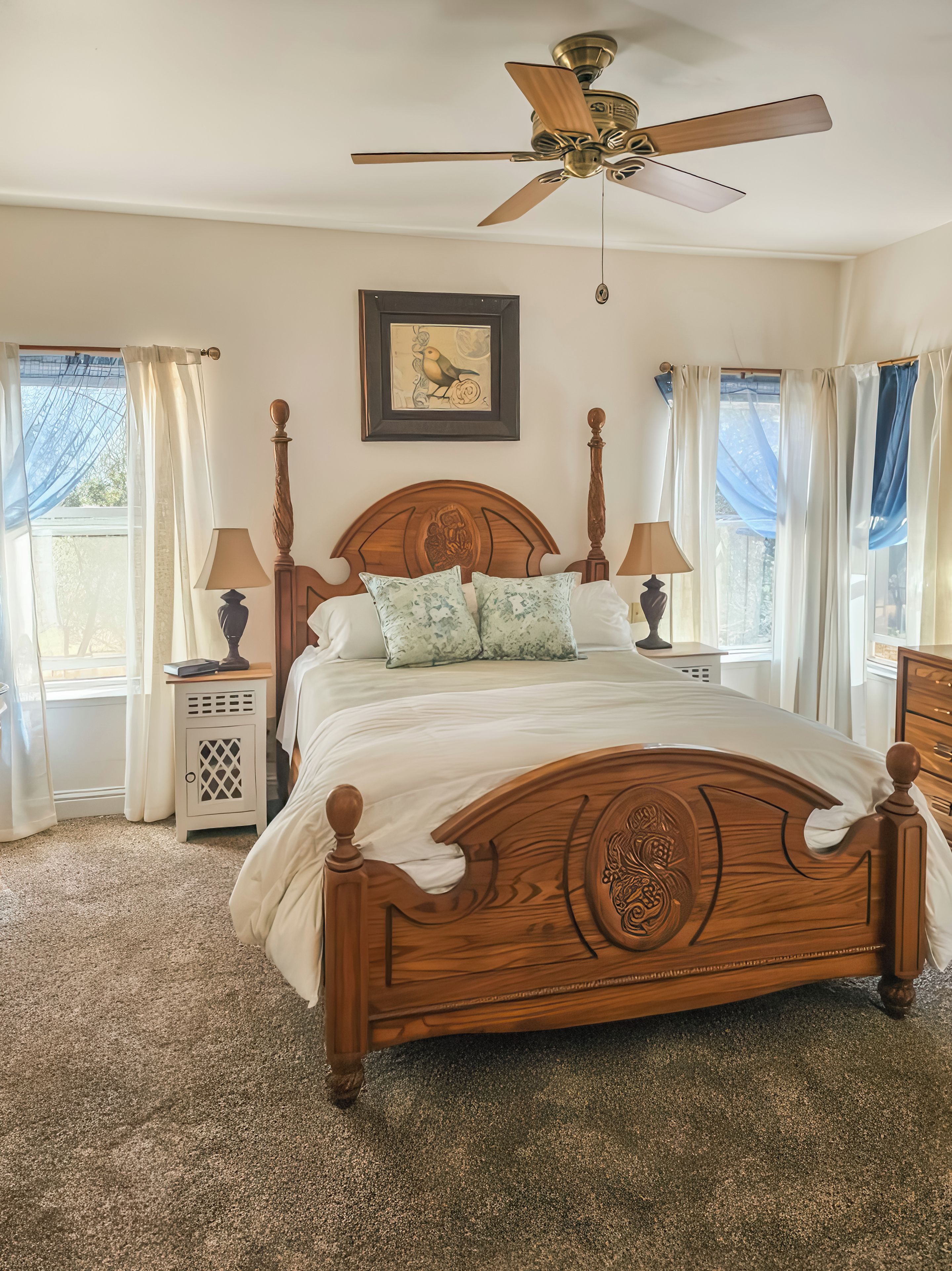 A bedroom with a wooden bed, a ceiling fan, and a window with curtains.
