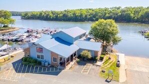 A marina with boats docked, a building with a sign 'JOEYS', and a parking lot. - Hickory Heaven by the Lake (New London)