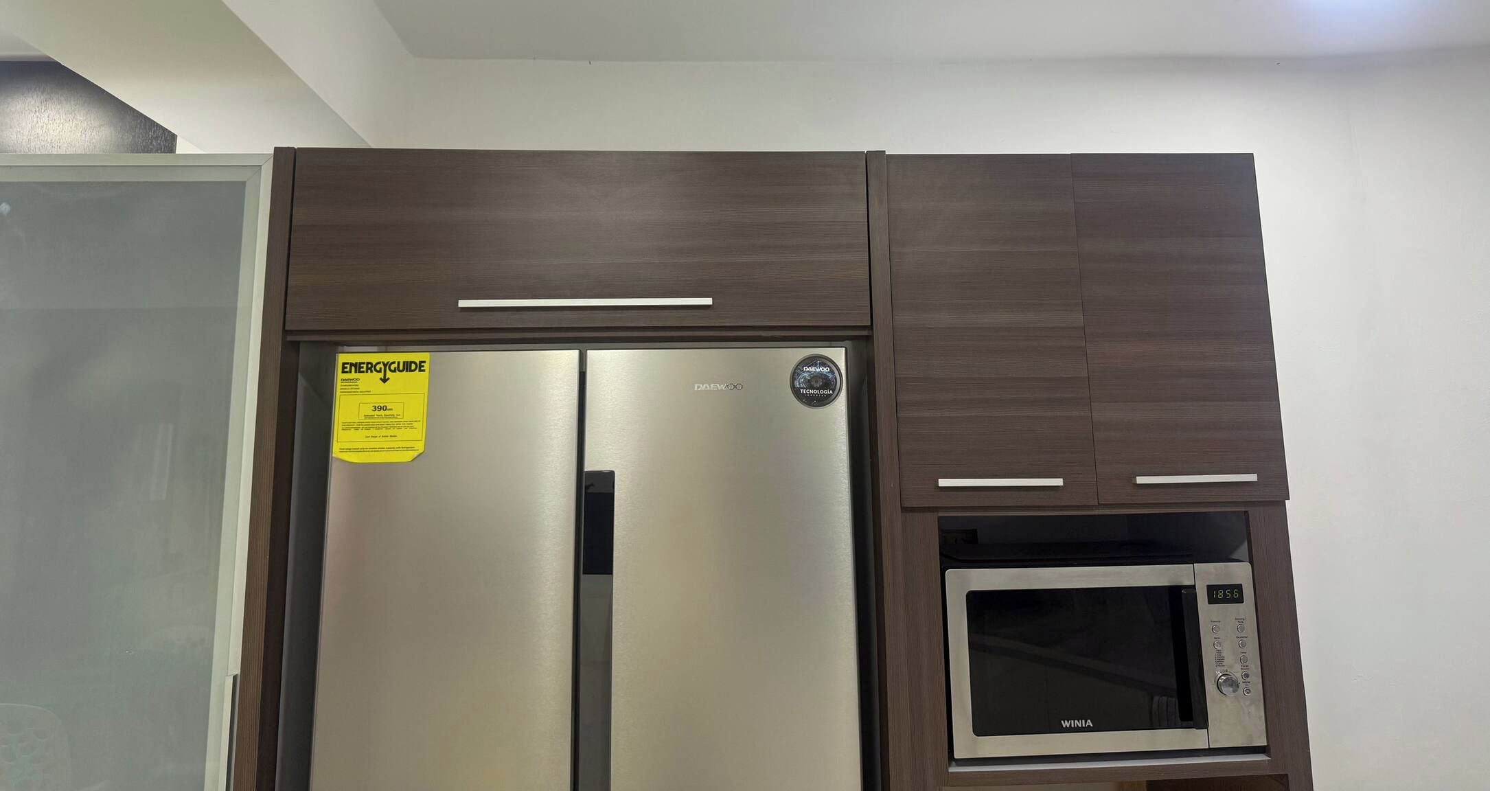 A kitchen with a stainless steel refrigerator and a built-in microwave.