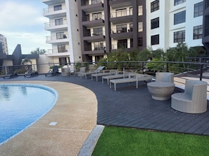 A rooftop pool area with lounge chairs and a small pool.