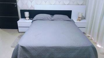 Een moderne slaapkamer met een bed, nachtkastjes en een wand met een cirkelpatroon.
