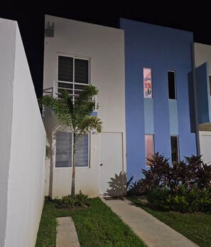 A modern building with a flat roof, a small tree, and a pathway leading to the entrance. - Casa Tlalocan Acapulco (Acapulto)