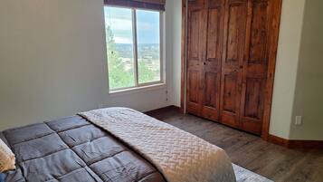 Un dormitorio con una cama grande, una ventana y un armario de madera.