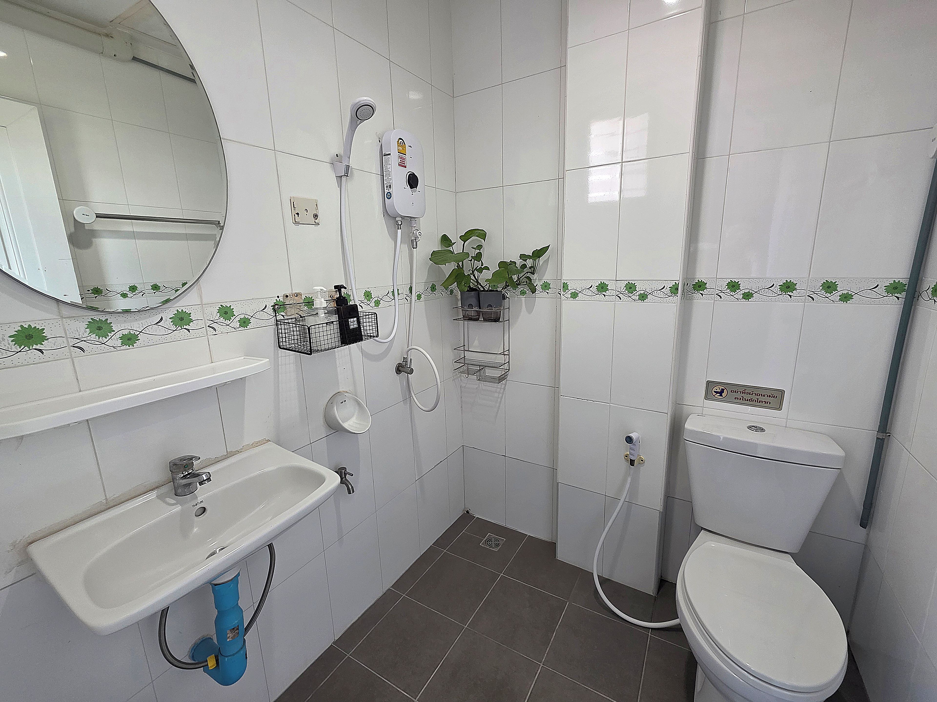 Ein Badezimmer mit Waschbecken, Toilette, Dusche und Spiegel.