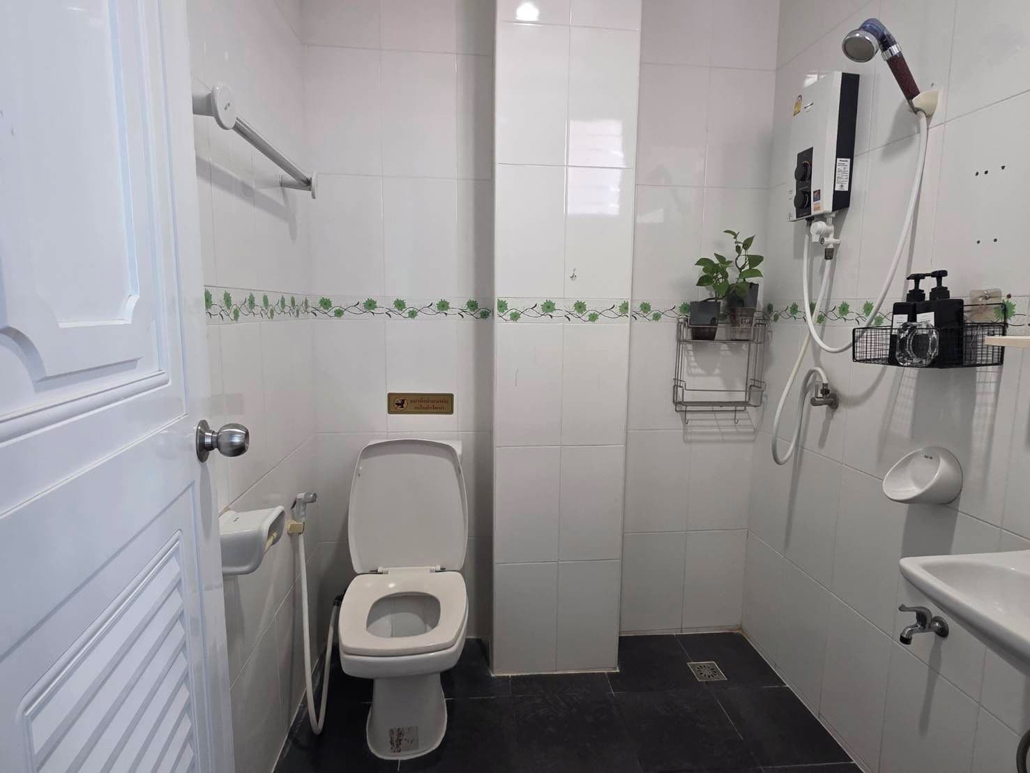 Un baño pequeño y funcional con inodoro, zona de ducha y lavabo.