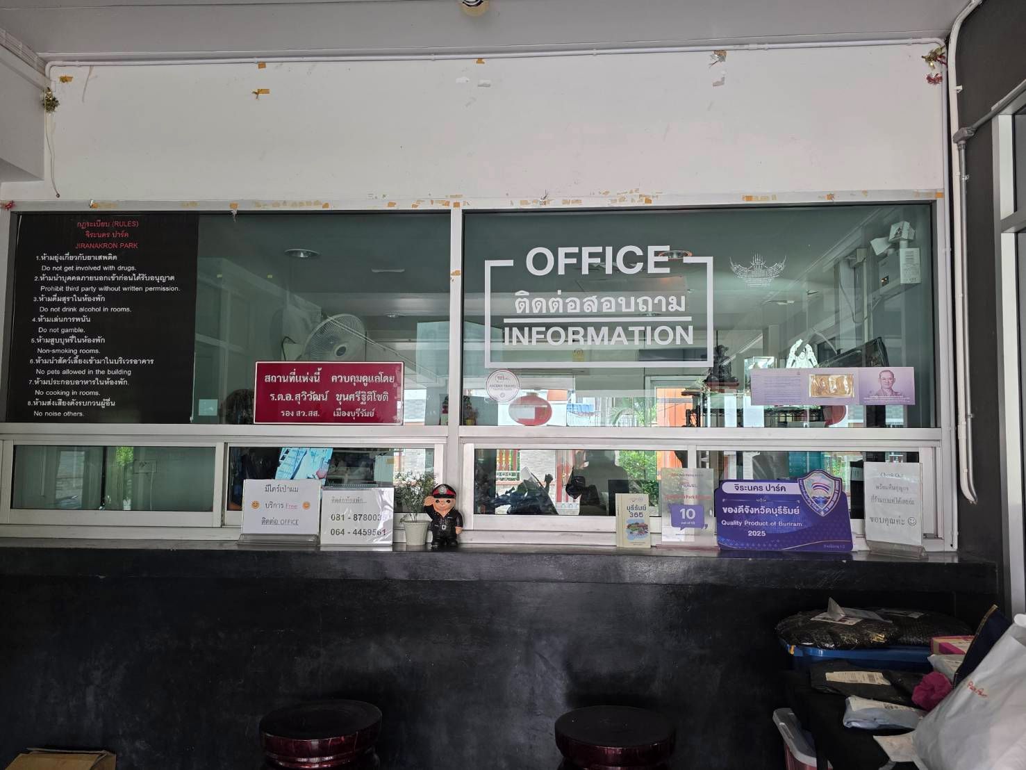 Un área de oficina con un cartel que indica 'OFFICE INFORMATION' y una lista de normas en la pared.
