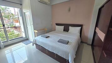 Habitación de hotel con cama, ventana y equipo de aire acondicionado.