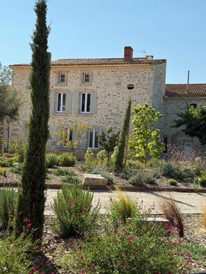 A stone building with a garden in front. - Domaine de Grange Basse (Vendres)