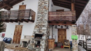 Ein zweistöckiges Gebäude mit einer Steinfassade, hölzernen Balkonen und einem Kamin.