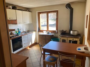 A compact kitchen with a stove, sink, and window.