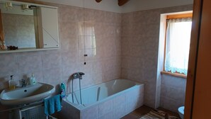 Ein Badezimmer mit Waschbecken, Spiegel und Badewanne.