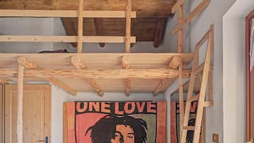 Et værelse med synlige træbjælker, en dør og et plakat med teksten 'ONE LOVE' på væggen.