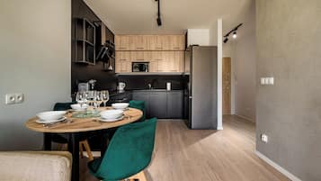 A modern kitchen with wooden cabinets, a built-in microwave, and a stainless steel refrigerator.