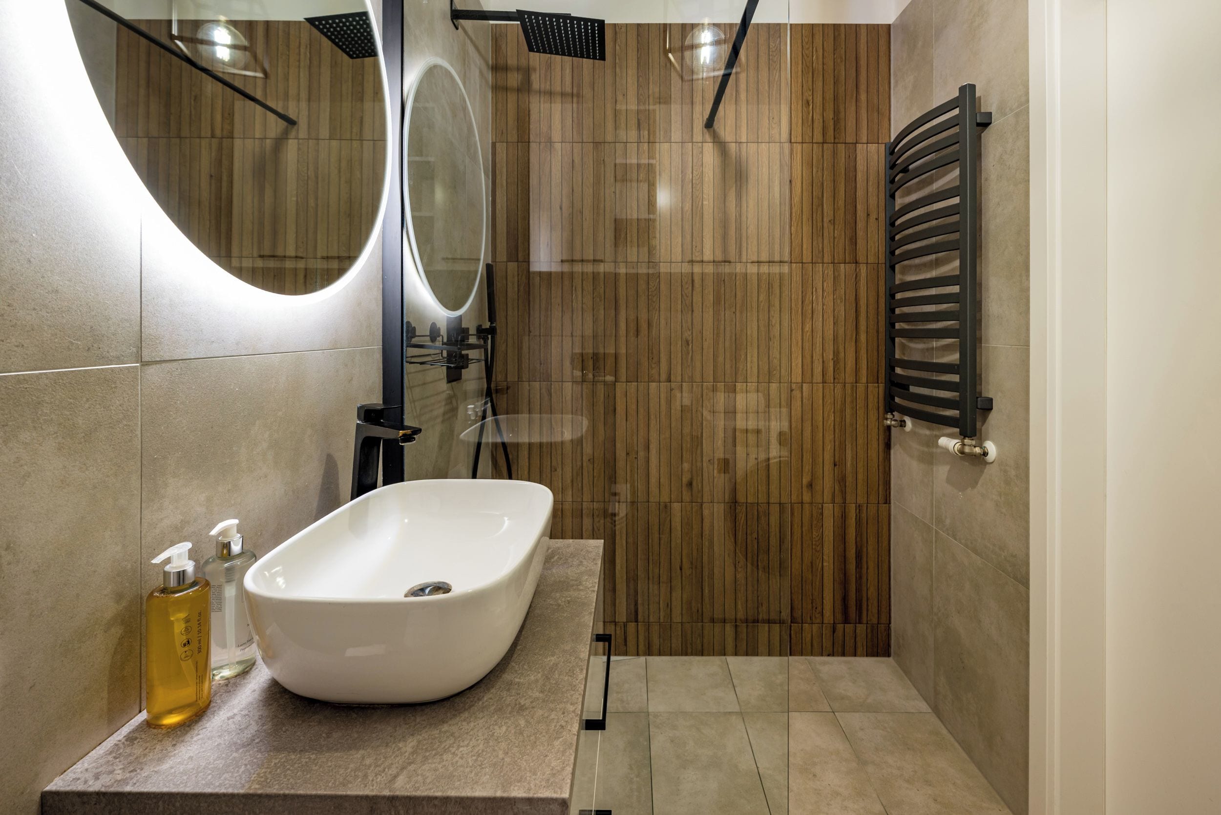 Ein modernes Badezimmer mit einer freistehenden Badewanne, einem großen Spiegel und einem Handtuchhalter.