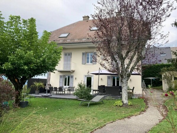A two-story house with a patio, a lawn, and a tree. - Holiday Home in Trevigin With Wi-fi (Trevignin)