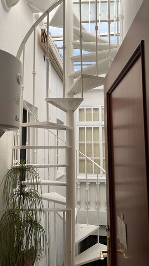 Eine Wendeltreppe mit weißen Geländern und einer Holztür mit Messingklinke.