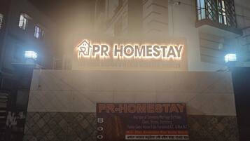 Letrero de PR-HOMESTAY con información de contacto y servicios ofrecidos.