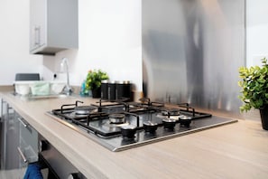 A modern kitchen with a stainless steel range hood, a wooden countertop, and a potted plant. - Ground-Floor 2BR Newcastle Retreat | Sleeps 4 (Newcastle upon Tyne)
