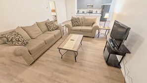 A living room with a sofa set, a coffee table, and a television. - Quiet Midland Family Home (Midland)