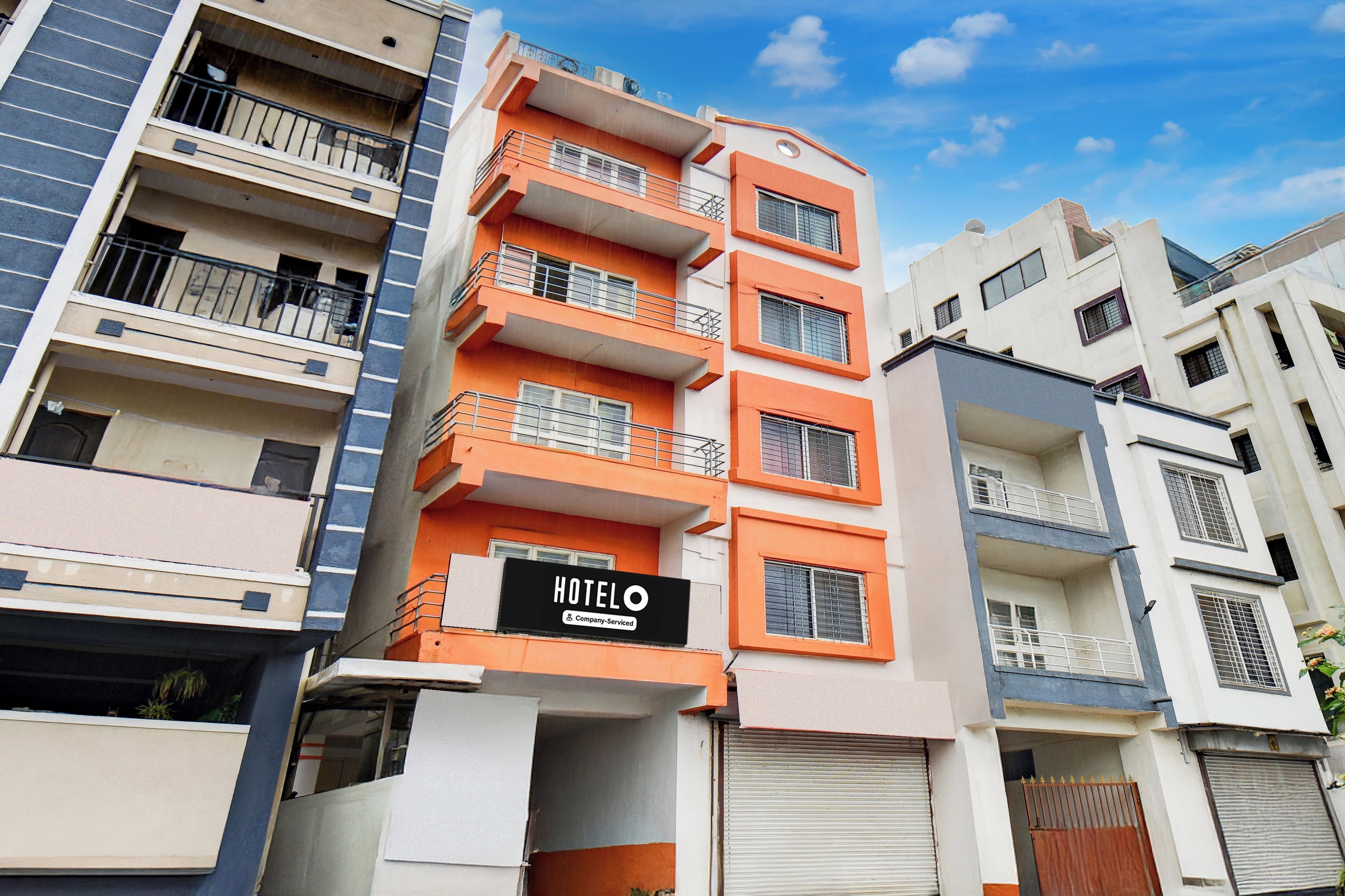 Un hotel de varios pisos con balcones y un cartel que indica que ofrece servicios para empresas.