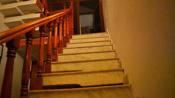 A wooden staircase with a handrail leading to a landing.