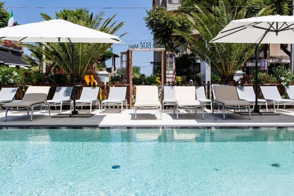 Una piscina al aire libre, una piscina climatizada, sombrillas