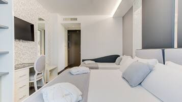 Una habitación de hotel con cama, escritorio, silla y televisión.