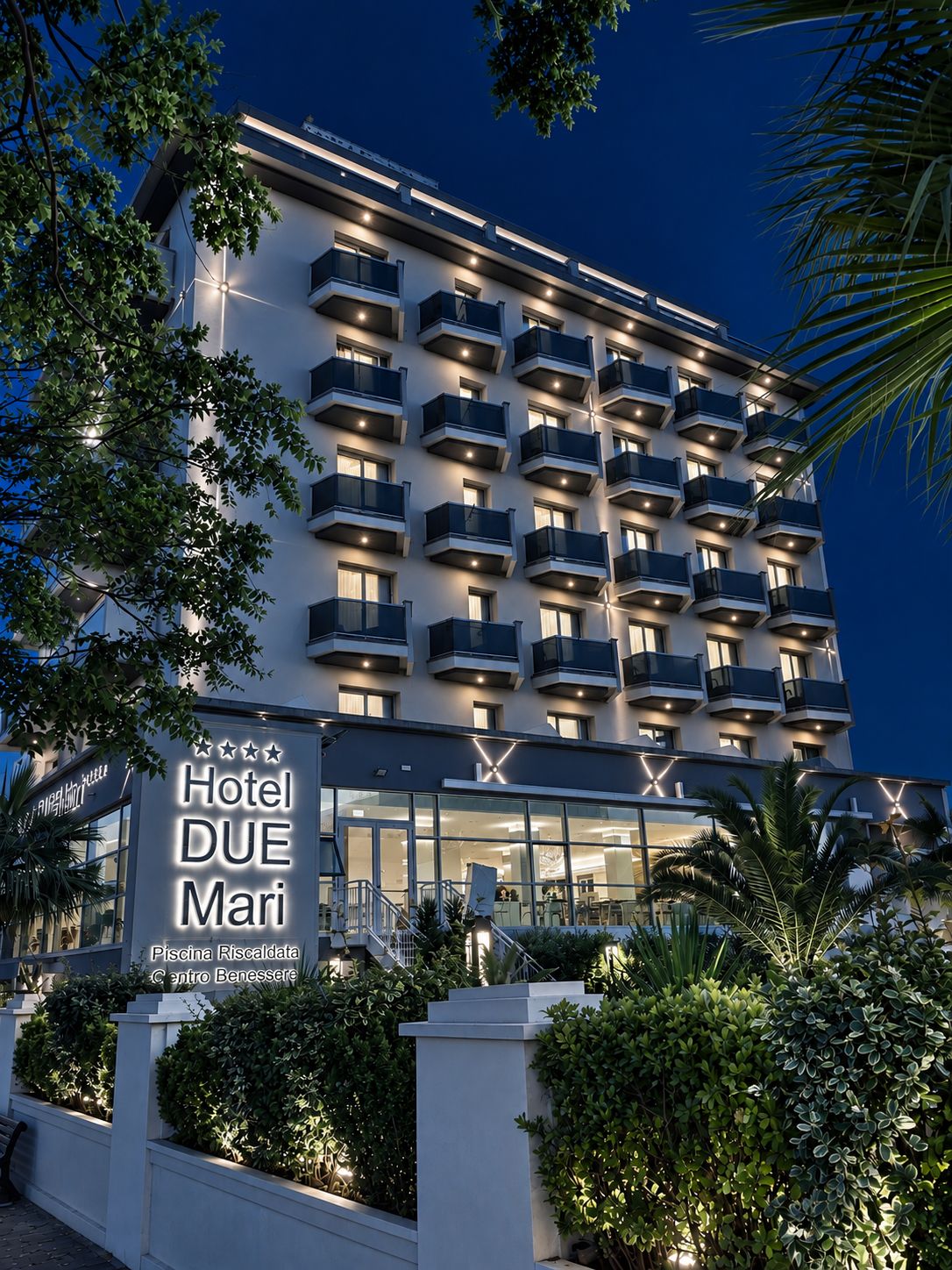 Un edificio de hotel de varios pisos con balcones y un cartel que indica 'Hotel DUE Mari'.