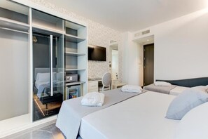 Una habitación de hotel moderna con una cama grande, un escritorio, un armario y una televisión.