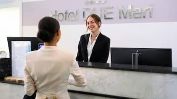 Una recepción de hotel con un letrero que dice 'Hotel BLUE Mari' y un monitor de computadora.