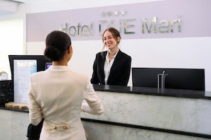 Una recepción de hotel con un letrero que dice 'Hotel BLUE Mari' y un monitor de computadora.
