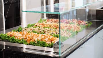 Un buffet où diverses préparations culinaires sont présentées dans une vitrine.