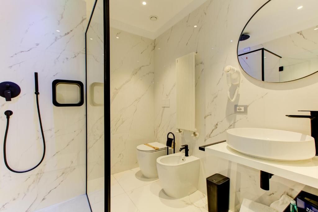 Ein modernes Badezimmer mit Marmorboden, einem runden Waschbecken, einer Toilette und einem Bidet.