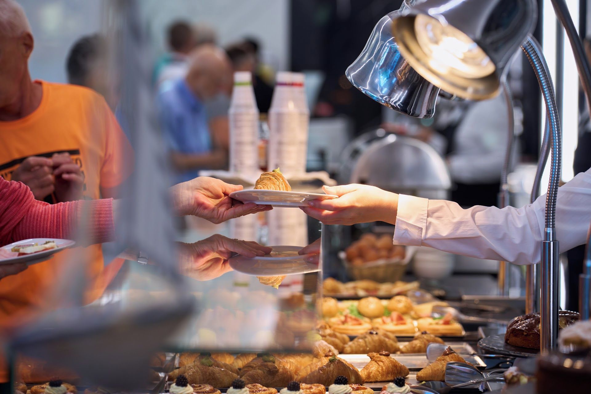 Un área de comida con una variedad de pasteles y postres exhibidos en una vitrina.