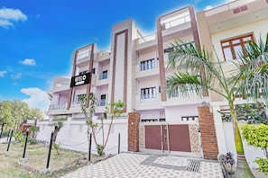 A multi-story hotel with a sign indicating it is a company-serviced hotel. - Hotel O Garden View Vrindavan Lucknow (Lucknow)