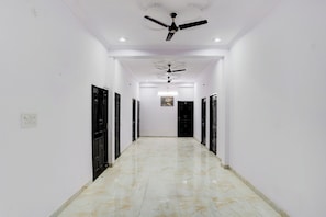 A hallway with a ceiling fan, recessed lighting, and a marble floor. - Hotel O Garden View Vrindavan Lucknow (Lucknow)