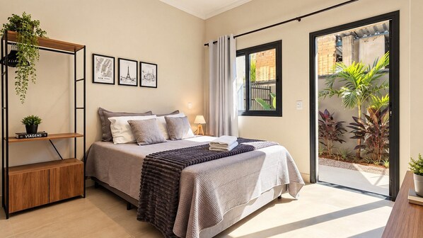 A bedroom with a bed, a bedside table, a wardrobe, a window, and a view of the outside. - STUDIO 04 (Vinhedo)