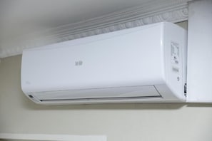 Aire condicionador mural blanc amb panell de control al costat dret.