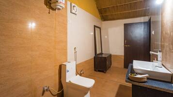 Un baño con inodoro, bidé, lavabo, espejo y calentador de agua instalado en la pared.