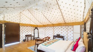 Une pièce aménagée avec une tente, un lit, une chaise, un bureau et un miroir.