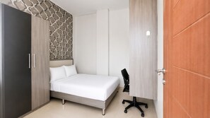 Un dormitorio con cama, escritorio y armario.