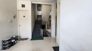 Un estrecho pasillo con una escalera que sube a un piso superior.
