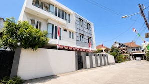 A modern two-story building with a gated entrance, a clear sky, and a parked car in the driveway. - Hotel O near Mall Panakkukang (Makassar)