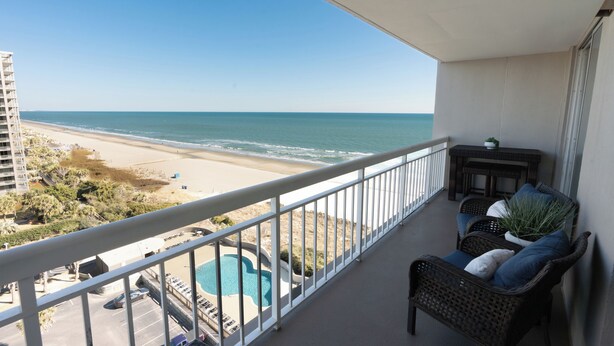 A balcony with a view of the beach and ocean, a pool, and outdoor furniture. - S Hampton 1107 2 Br Oceanview in Kingston, Pool (Myrtle Beach)