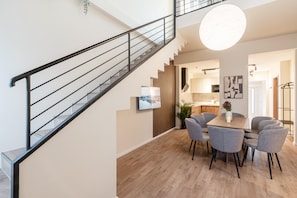 Un interior moderno con una escalera, comedor y cocina.
