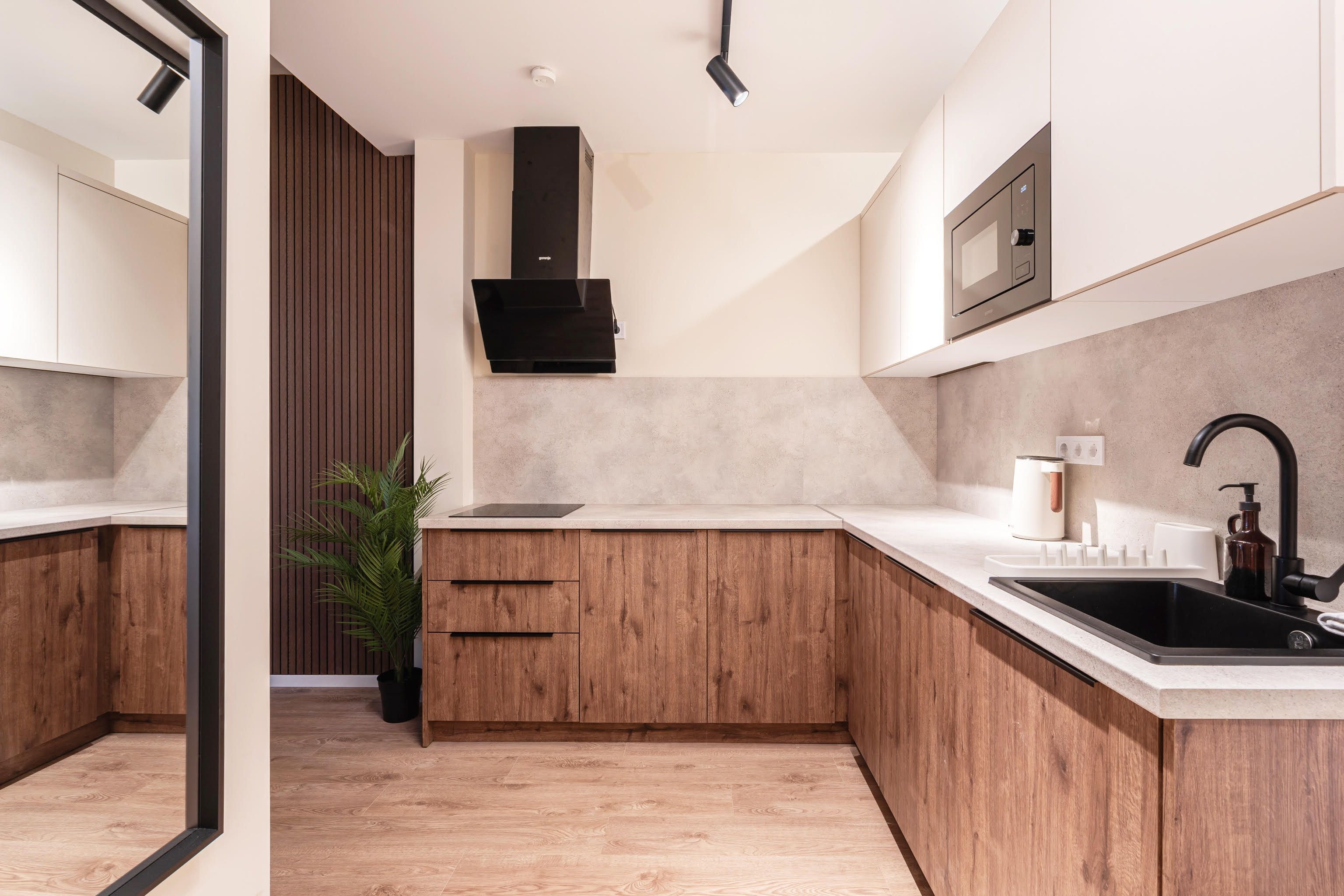 A modern kitchen with wooden cabinets, a built-in stove, a sink, and a countertop.