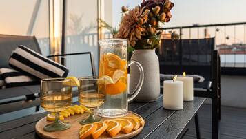Et bord med en kande, glas og appelsinskiver på en træplade.