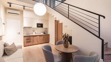 Een modern appartement met keuken, eethoek en trap.