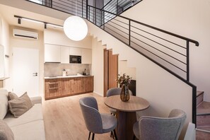 A modern apartment with a kitchen, dining area, and staircase. - LimeTree Residence by BQA (Budapest)