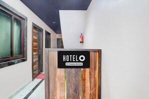 A hotel entrance with a wooden sign indicating it is company-serviced. - Super OYO Hotel O Tedhi Bazaar (Ayodhya)